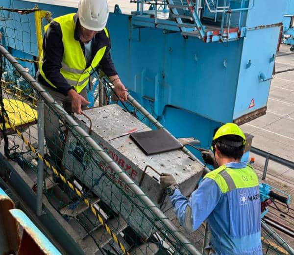 Men on a staircase carrying a transport crate.