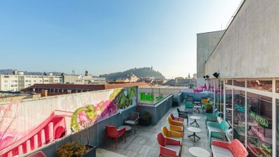 Rooftop bar of a hotel, with mountains in the background.
